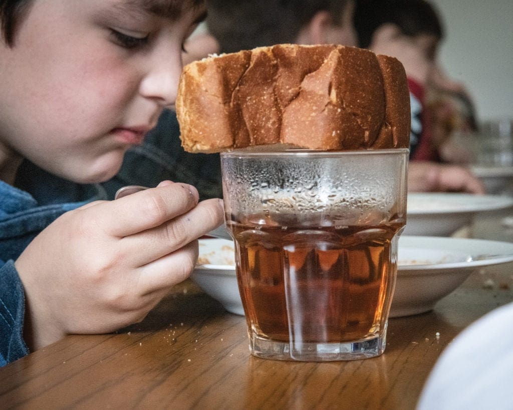 a child eats a meal at a table at the Caritas youth center.