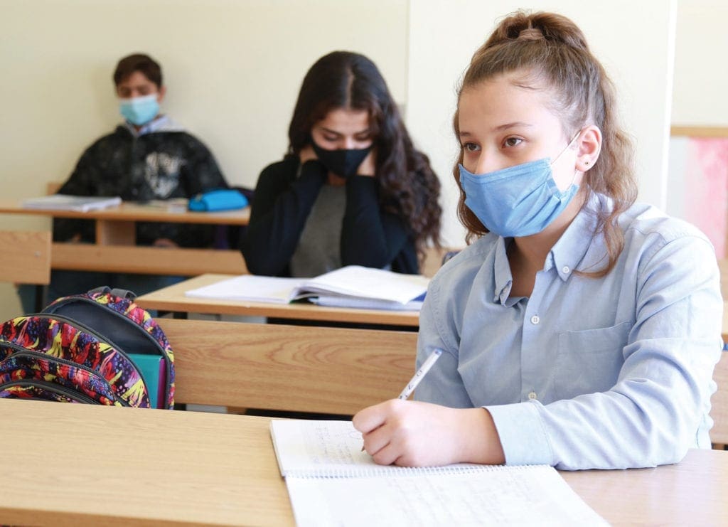 a student takes notes at her desk.