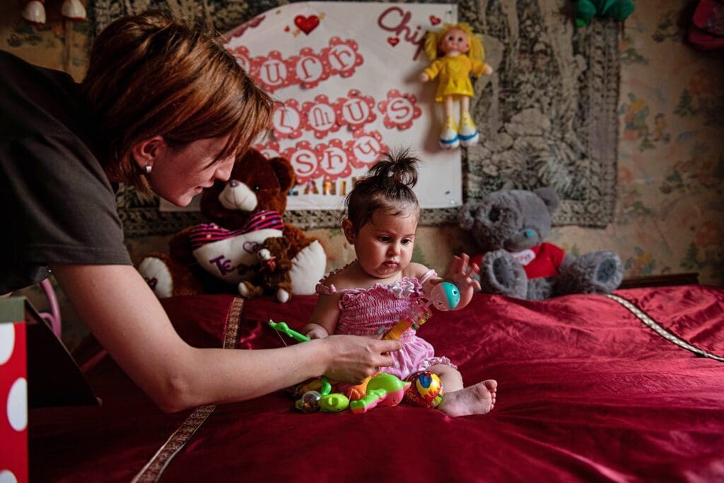 a woman plays with a toddler.