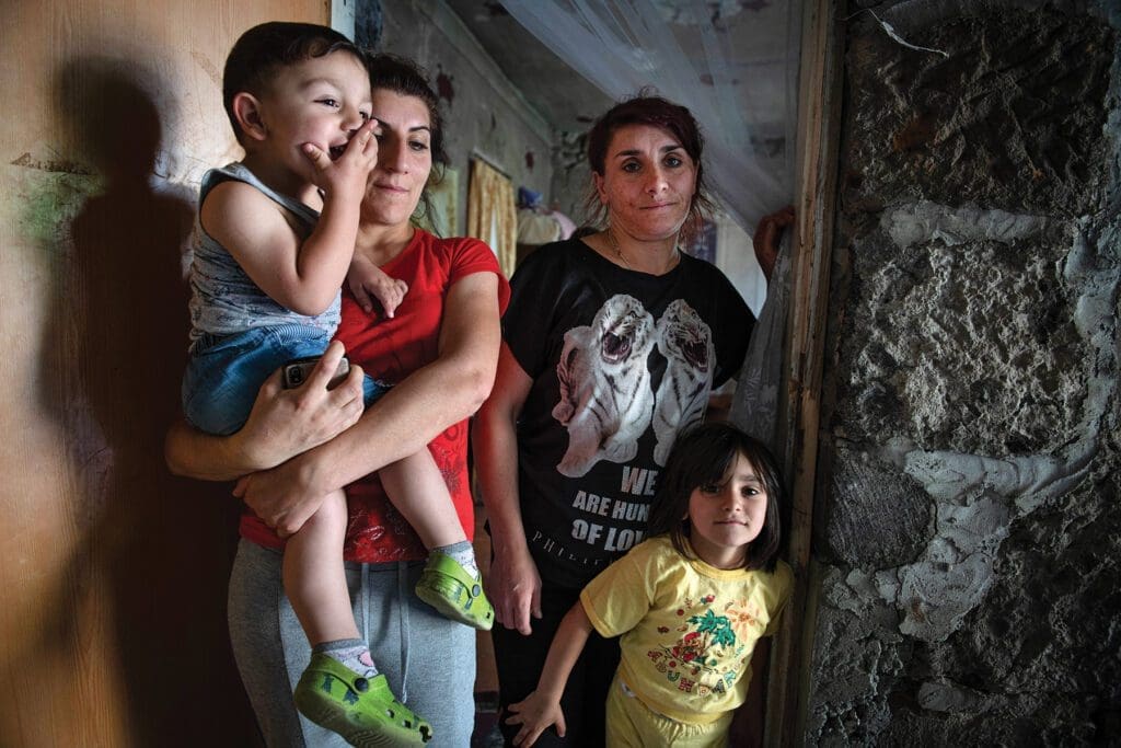 a family of four crowds together in a doorway.