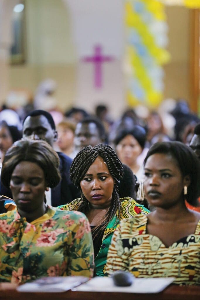 a crowd of refugees in egypt sits in church,