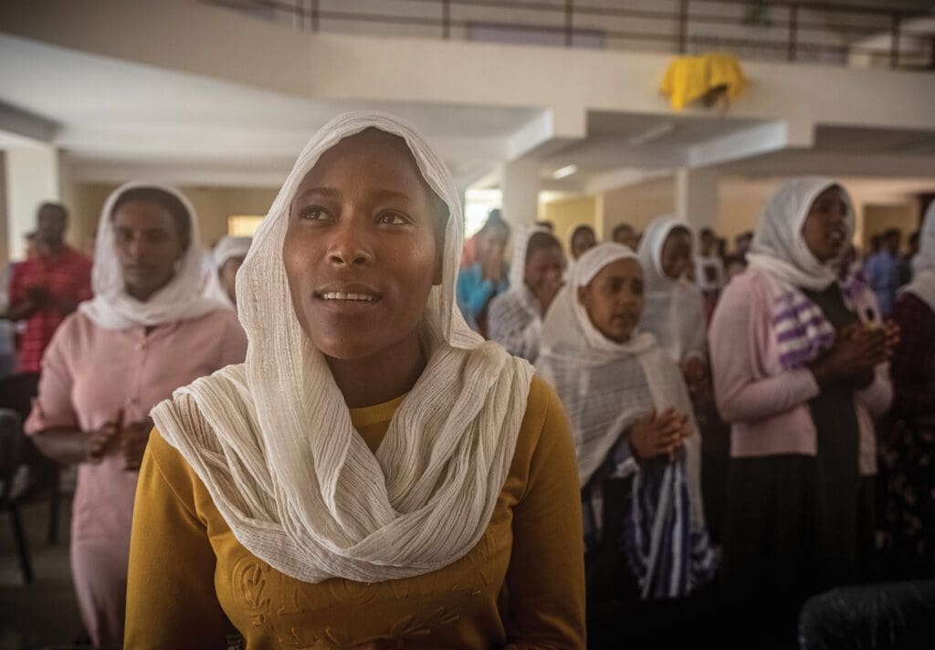 university students in ethiopia pray in a large gathering.