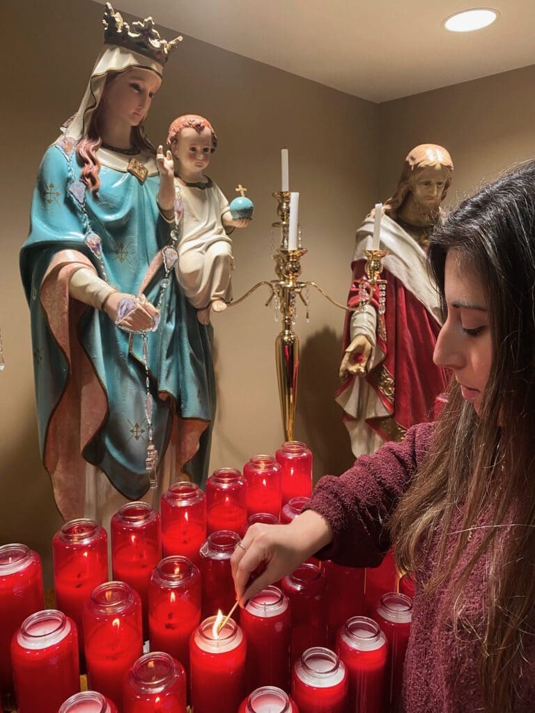 Sandy Risha lights a candle at her parish, St. George Maronite Catholic Church, in Uniontown, Pennsylvania.