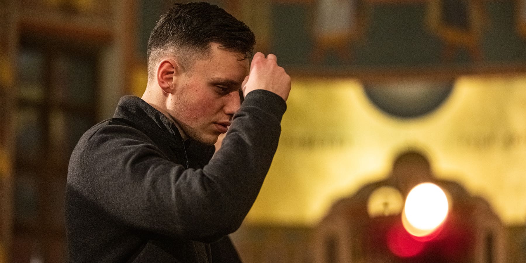 a young man prays in a church in ukraine