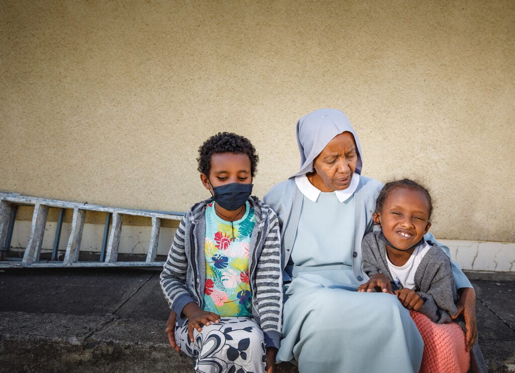 A nun with two students on either side.