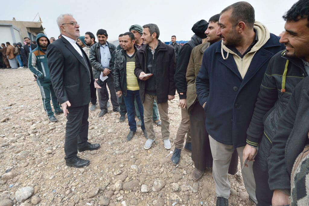 A Priest addressing a line of men.