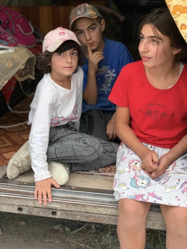 Three children who live in an abandoned train car in Armenia.