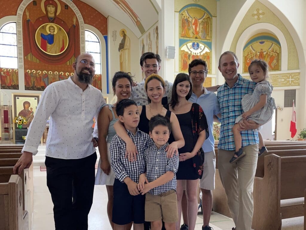 A group of diverse parishoners stands in a church