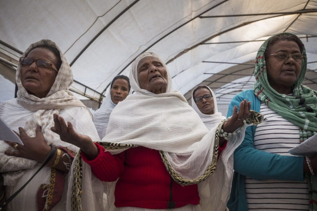 Ethiopian women pray under a white tent in Addis Ababa.