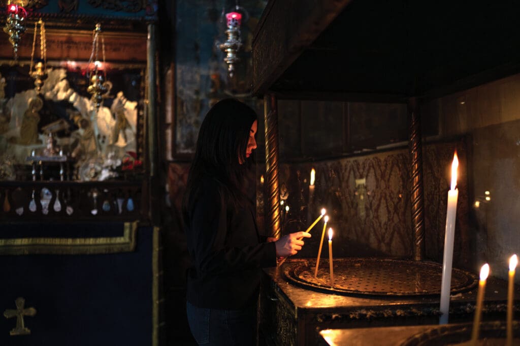 A woman lights a candle.