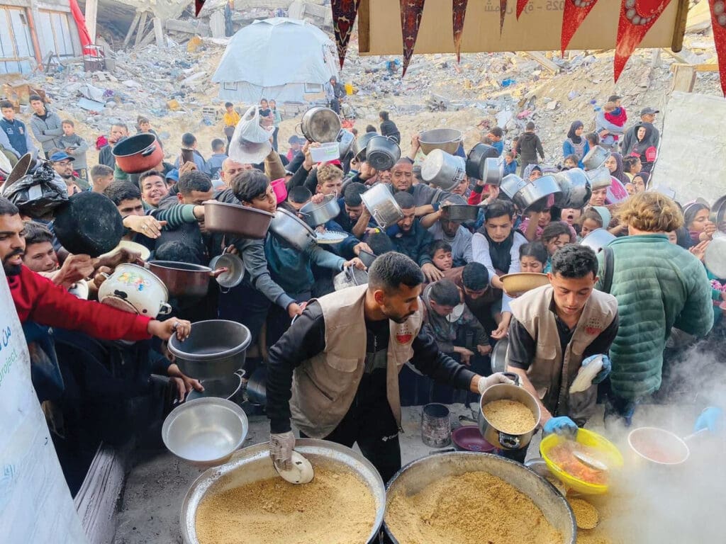 A crowd of people scrambling for food.