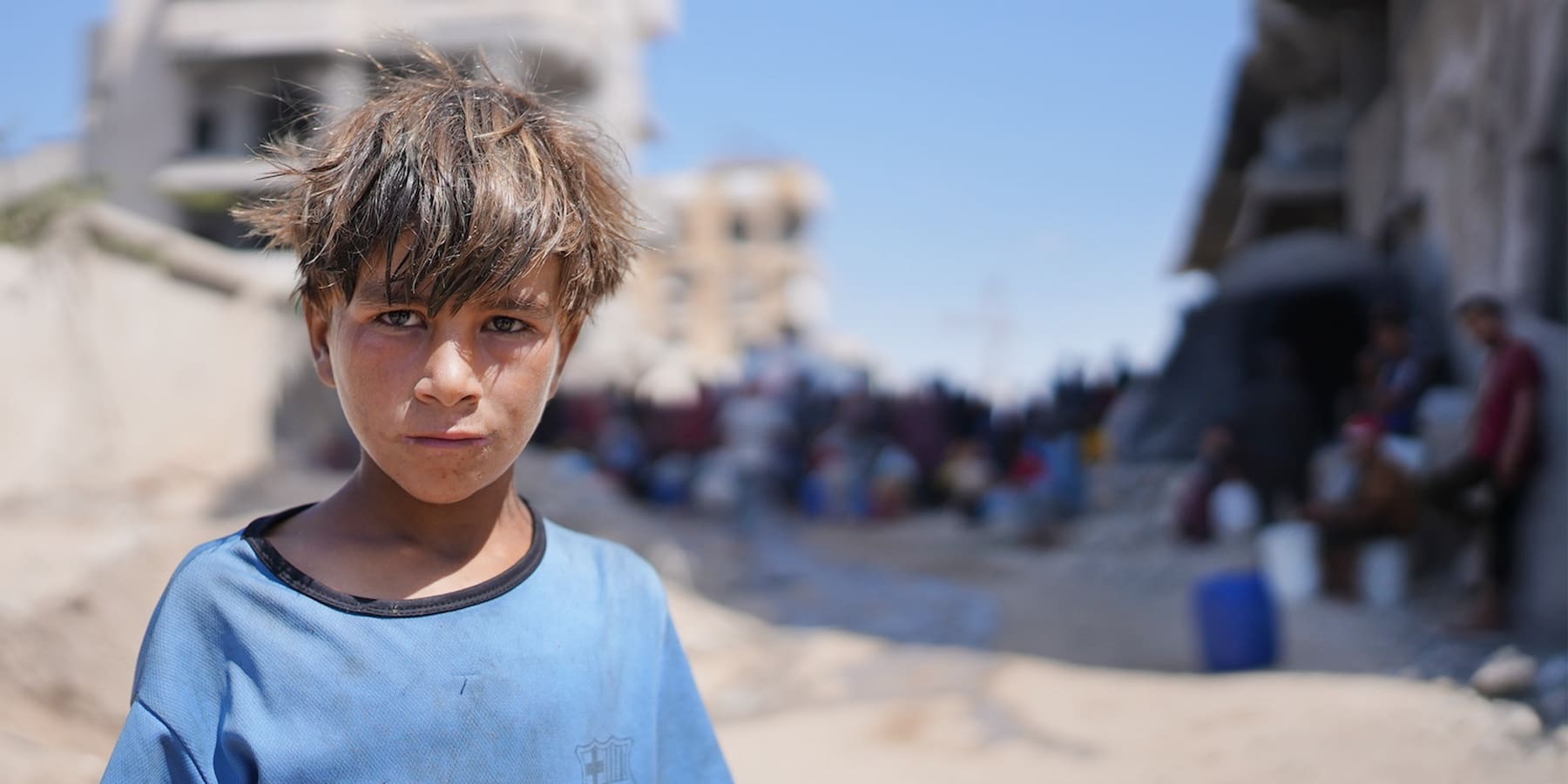 Image of poor child standing on a dirt road.