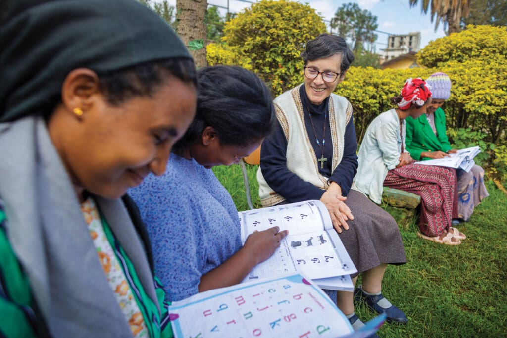 A woman teaches adult women to read.