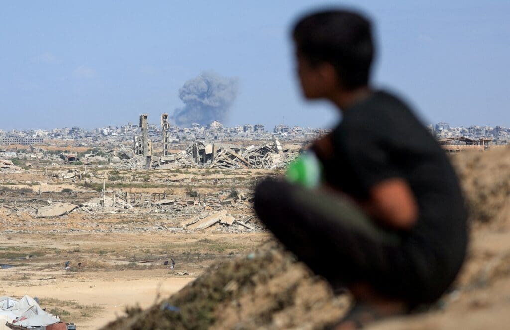 Shadow of a boy looking at a destroyed city.