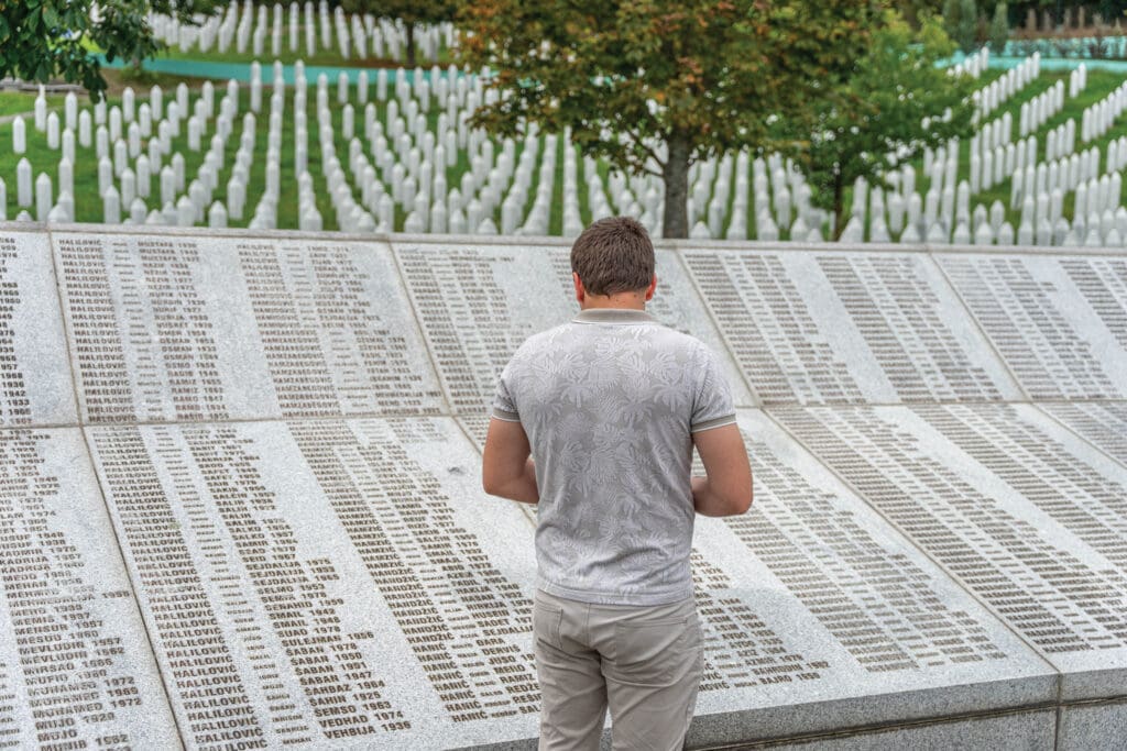 The back of a man looking at the Srebrenica Genocide Memorial in Potočari.