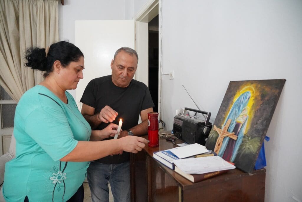 A man and a woman light a candle.