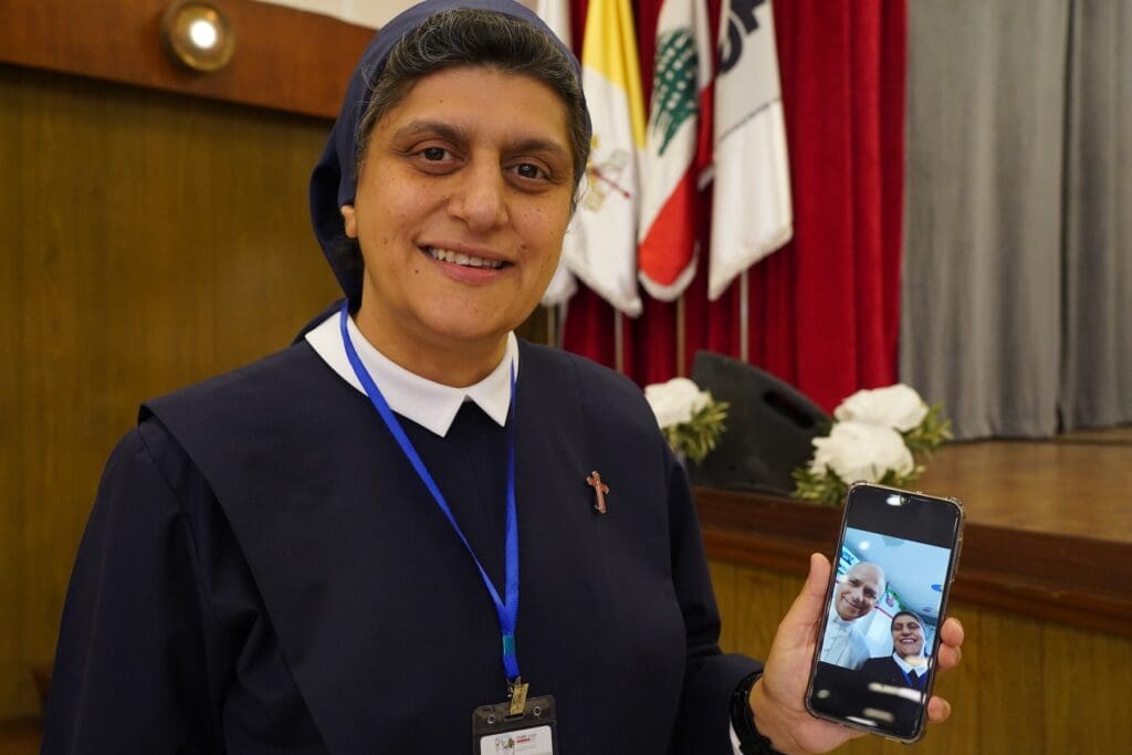 A religious sister holds a cell phone showing a selfie she took with Pope Leo XVI.