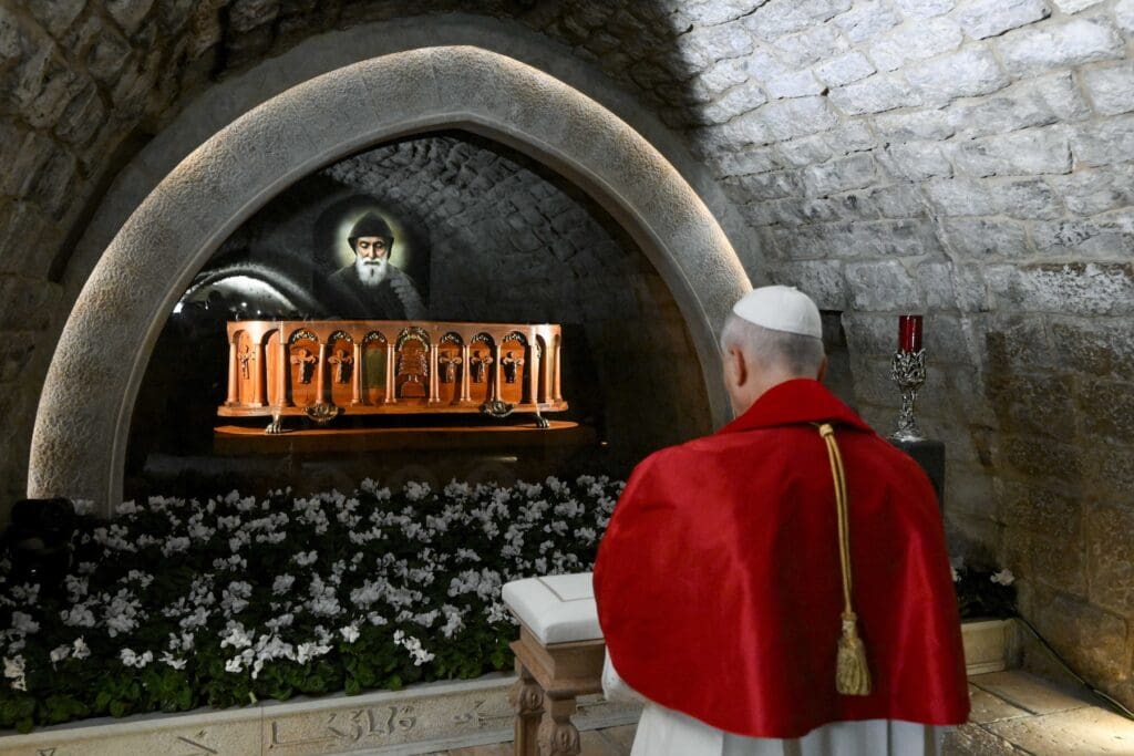 Pope Leo XI prays before the tomb of St. Charbel.