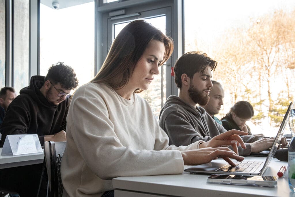 A woman using a laptop in a classroom.