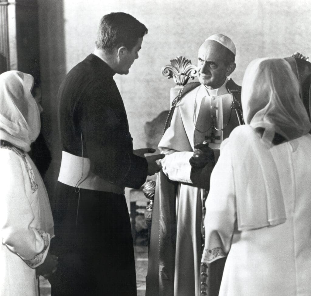 A priest greets Pope Paul VI.
