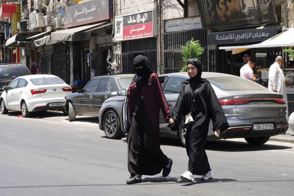 twi muslim women crossing a street.