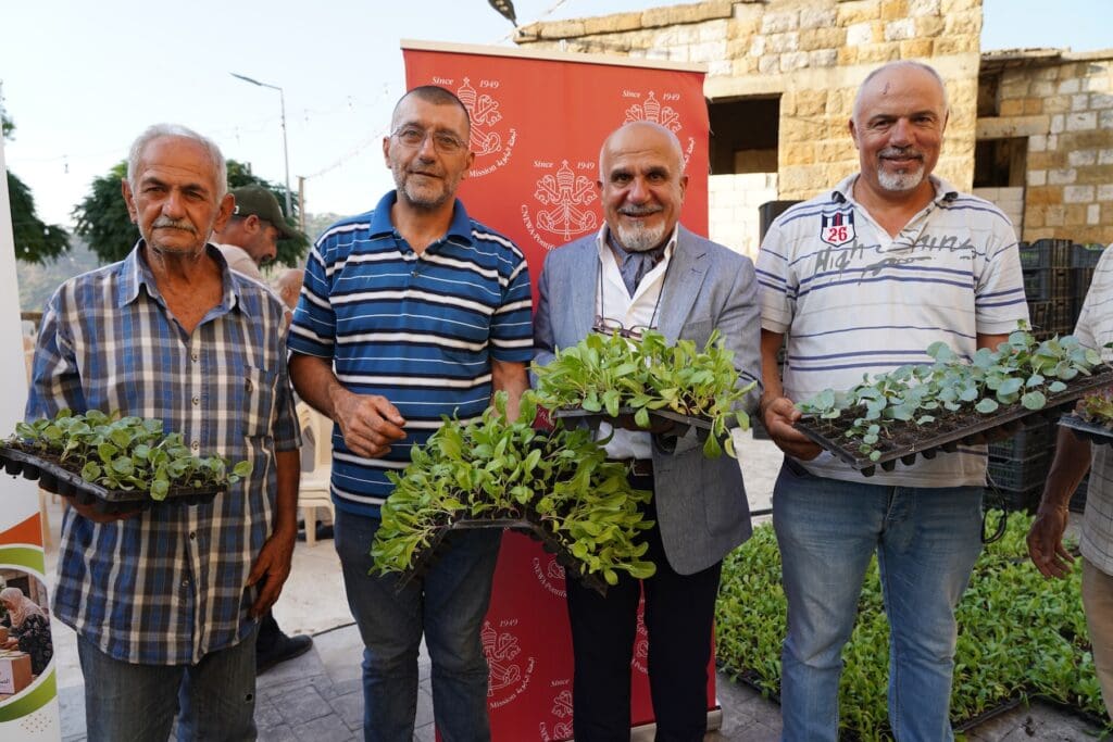 Four men showing seedlings.